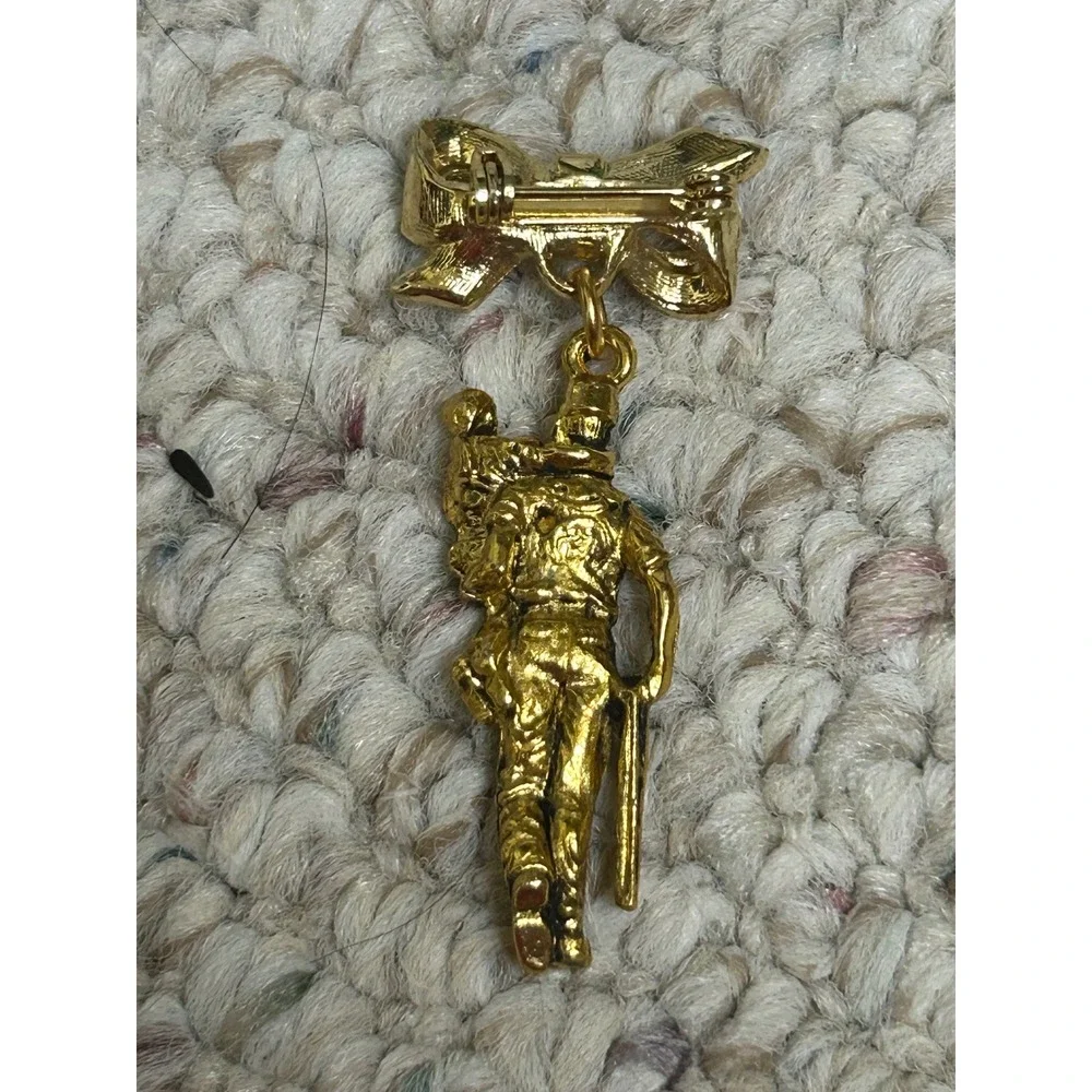 Vintage Gold Tone Soldier Carrying Child Bow Dangle Brooch Pin Commemorative